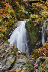 Rausch waterfall behind rocks in the Rhineland Palatinate forest of Germany on a fall day.