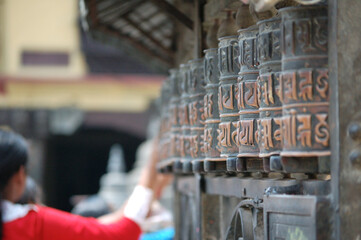 Woman spinning the prayer wheels with mantras in Kathmandu, Nepal 