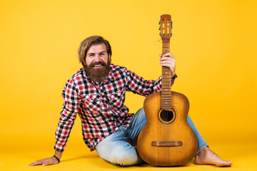 Guitar player on yellow background. Cheerful guitarist. charismatic mature man playing guitar while...