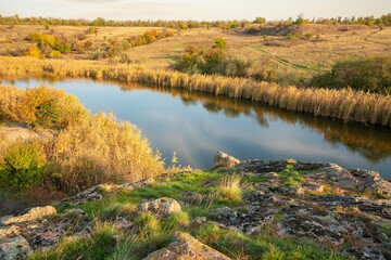 A small pile of stones in a green-yellow field against the background of sky in beautiful Ukraine