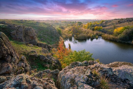 A small pile of stones in a green-yellow field against the background of sky in beautiful Ukraine