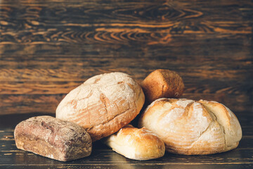 Assortment of fresh bread on wooden background