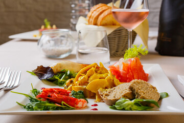Antipasto da ristorante con seppie al curry, calamaro grigliato, salame di tonno, gamberi scottati e salmone marinato alla barbabietola