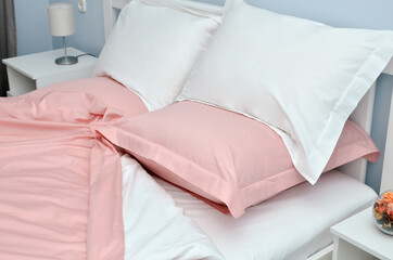 Bed in the hotel covered with pink linens