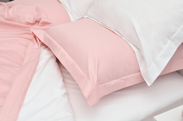 Bed in the hotel covered with pink linens