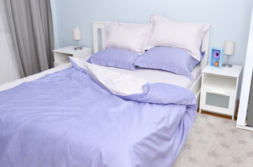 Bed in the hotel covered with blue linens