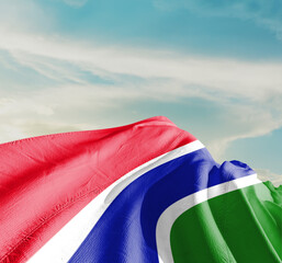 Gambia national flag waving in beautiful clouds.