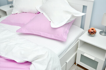 Bed in the hotel covered with pink linens