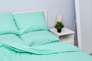 Bed in the hotel covered with green linens