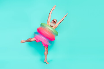 Photo of crazy clubber old man dance raise hands wear pile lifebuoy sunglass shorts isolated teal color background