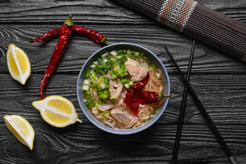 Composition with tasty Chinese soup on dark wooden background