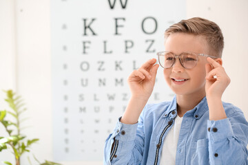 Little boy wearing glasses at ophthalmologist's office - obrazy, fototapety, plakaty