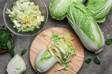 Board with fresh cut chinese cabbage on grunge background