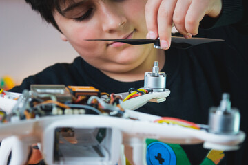 Physics Grant. A young inventor puts a propeller on a drone. Extracurricular physics classes in the home laboratory.