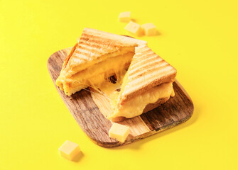 Tasty sandwiches with cheese on color background