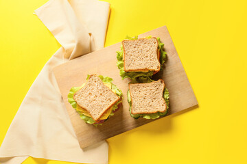 Board with tasty sandwiches on color background