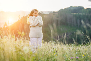 Fototapeta na wymiar happy woman enjoying sunset stay on the green grass on the forest peak of mountain. Fresh air, Travel, Summer, Fall, Holidays, Journey, Trip, Lifestyle.