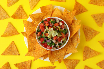 Pico de Gallo and chips on yellow background