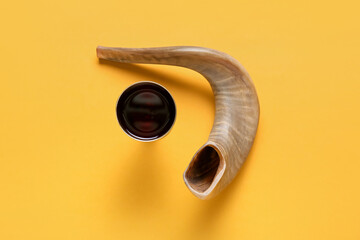 Sacramental goblet of wine and shofar on color background. Rosh hashanah (Jewish New Year) celebration