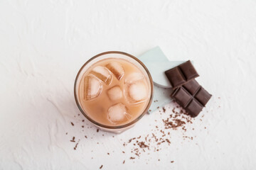 Glass of tasty chocolate milk on light background
