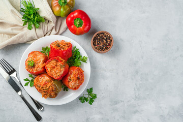 Stuffed bell pepper in a white plate on a gray background. Healthy food.