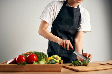 housewife in the kitchen cuts vegetables for salad healthy food
