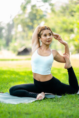 Young asian woman practicing yoga in garden.female happiness. blurred background.Healthy lifestyle and relaxation concept.Young Asian Girl doing yoga in the park.