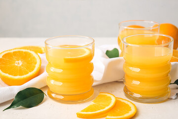 Glasses of tasty orange juice on light background, closeup