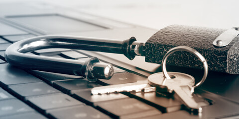 Computer security concept. Opened metal lock and keys on the keyboard. Selective focus, blur....
