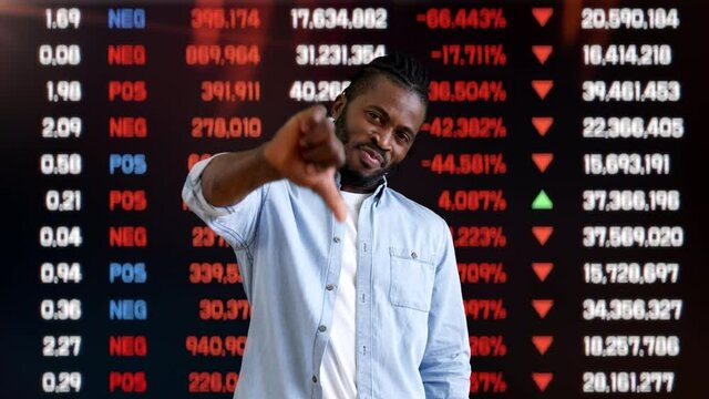 Unhappy man showing thumbs down on stock market background, bad investment, loss
