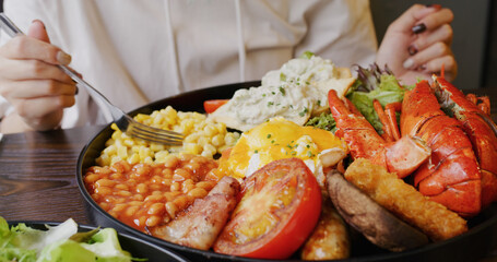 Woman enjoy all day breakfast in coffee shop