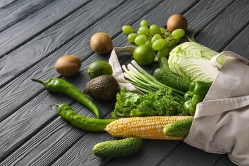 Eco bag with different products on wooden background