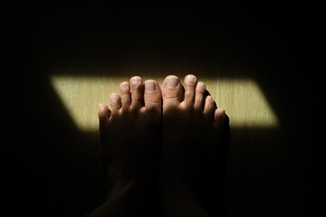 feet in the dark with light at toenail abstract background