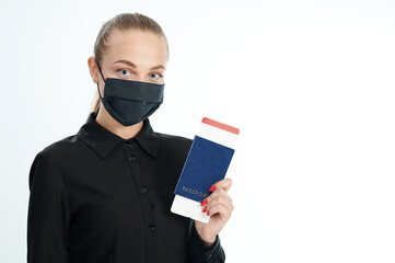 Woman in mask with flight ticket in passport