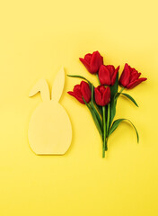 Fototapeta premium Bouquet red tulips on a yellow background and board for your text. Greeting card, invitations, big discounts, sales for the holidays.