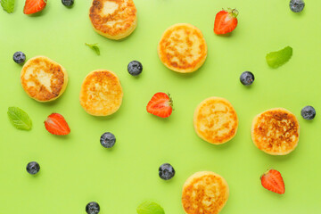 Cottage cheese pancakes, berries and mint on color background