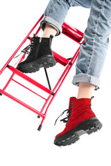 girl in trendy black and red shoes posing on the stairs in the studio on a white background....