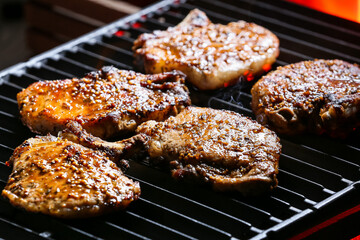 Tasty pork steaks on barbecue grill, closeup
