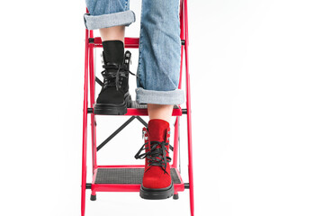 girl in trendy black and red shoes posing on the stairs in the studio on a white background....