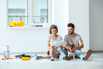 Young couple with cute dog and palette samples planning design of their new house