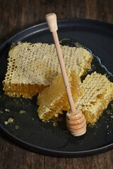 Honeycomb and honey dipper on wooden table