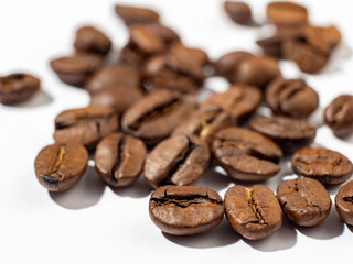 Brown roasted coffee beans on a white background.