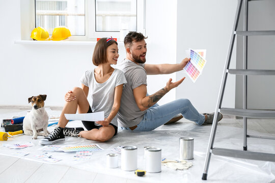 Young couple with cute dog and palette samples planning design of their new house