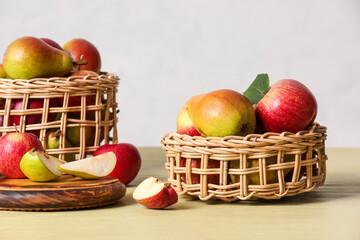 Wooden board and baskets with ripe fruits on table