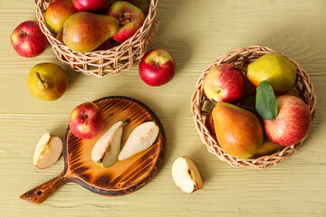 Wooden board and baskets with ripe fruits on table