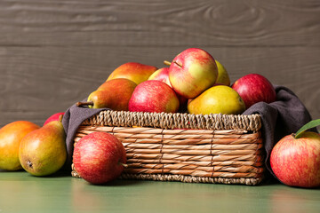 Box with ripe pears and apples on table