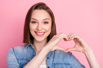 Photo portrait of girl in shirt showing heart sign on date smiling isolated pastel pink color...