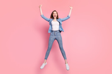 Full length body size photo girl smiling jumping up crazy wearing jeans outfit isolated pastel pink color background