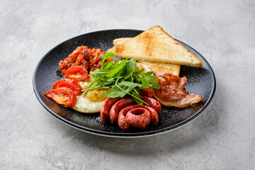 Fried eggs with sausage, bacon, tomatoes and beans