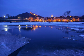 Naklejka premium Burglengenfeld, Eisschollen mit einer Stadt und einem Hügel im Winter